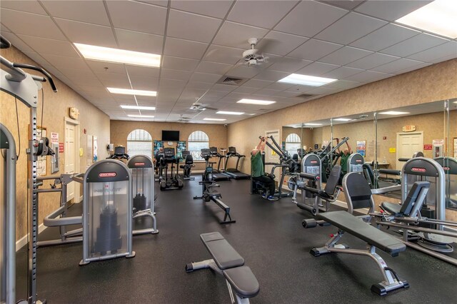 gym with a paneled ceiling and visible vents