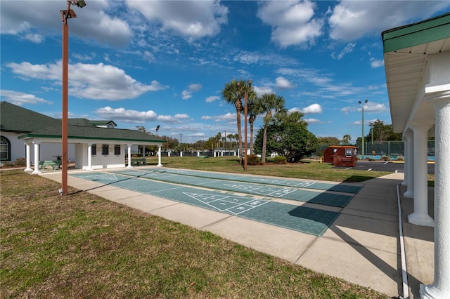 view of home's community with shuffleboard and a lawn