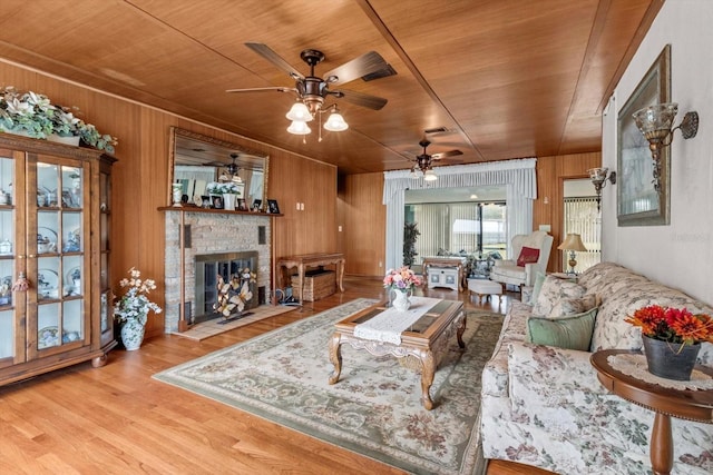 living area featuring wood ceiling, a fireplace, wooden walls, and wood finished floors