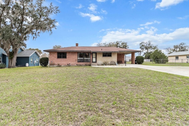 ranch-style house featuring driveway, fence, a front lawn, a carport, and brick siding