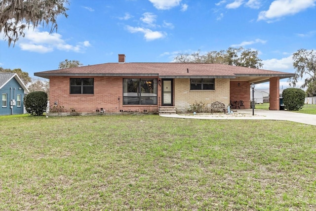 single story home with an attached carport, brick siding, and a front yard