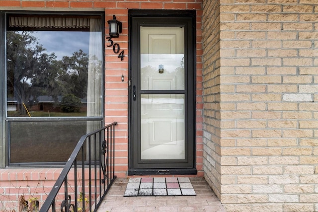 property entrance featuring brick siding