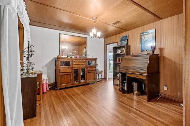 living area featuring a chandelier, wooden ceiling, wood walls, visible vents, and light wood-style floors