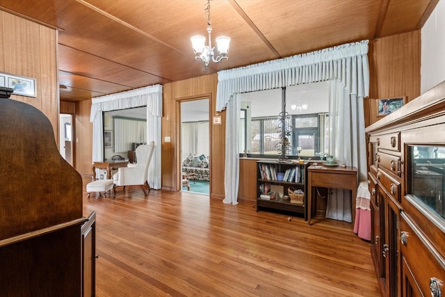 interior space featuring a notable chandelier, wood ceiling, wooden walls, and wood finished floors