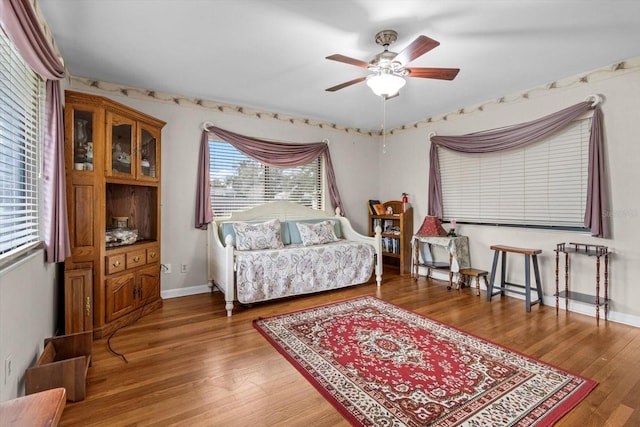 interior space featuring ceiling fan, baseboards, and wood finished floors