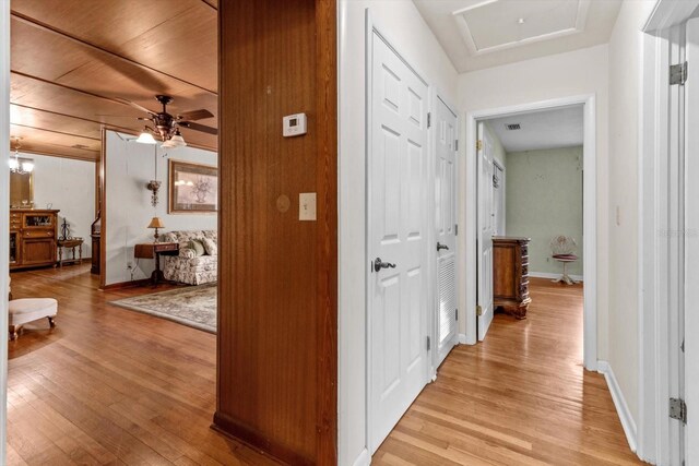 hall with light wood-style floors, visible vents, and baseboards