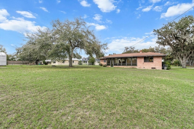 view of yard featuring a sunroom and fence