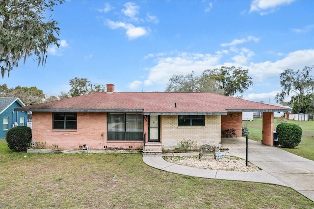 single story home featuring driveway, a chimney, roof with shingles, a front lawn, and brick siding