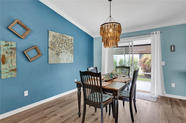 dining space featuring ornamental molding, wood finished floors, and baseboards