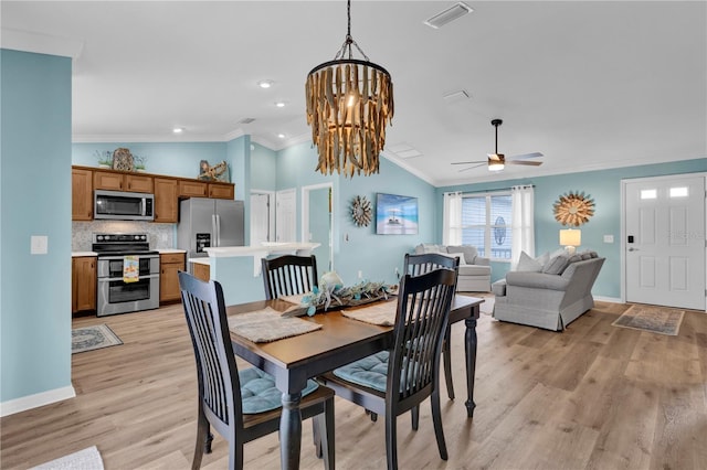 dining space featuring ceiling fan with notable chandelier, visible vents, baseboards, ornamental molding, and light wood-type flooring