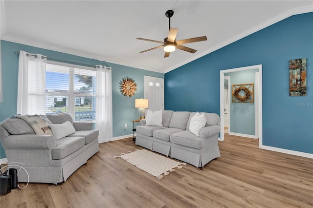 living room with wood finished floors, a ceiling fan, baseboards, vaulted ceiling, and ornamental molding