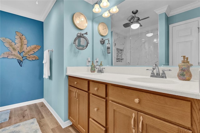 bathroom with wood finished floors, a sink, ornamental molding, a marble finish shower, and double vanity