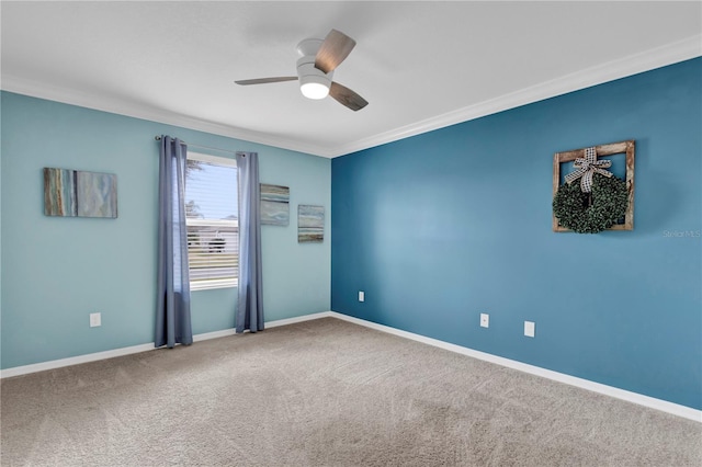 carpeted empty room featuring baseboards, a ceiling fan, and ornamental molding