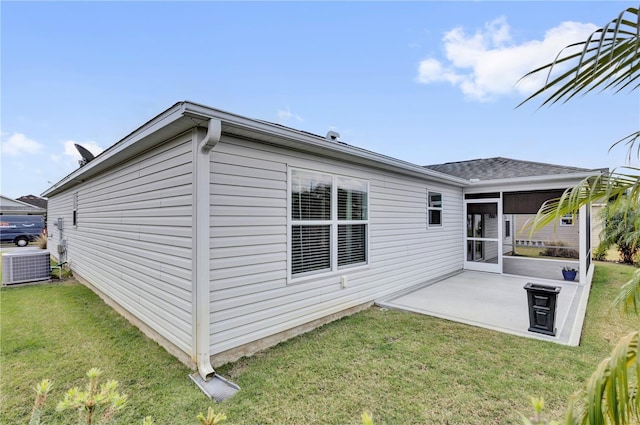 back of property featuring a lawn, a patio area, a sunroom, and central air condition unit