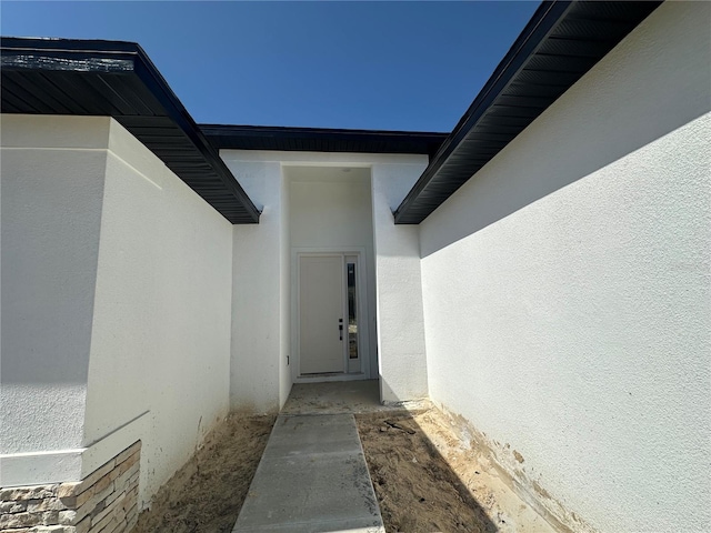 view of exterior entry featuring stucco siding