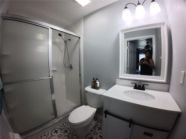 bathroom with toilet, a stall shower, and vanity