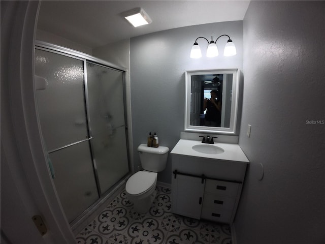 bathroom featuring vanity, a shower stall, toilet, and tile patterned floors