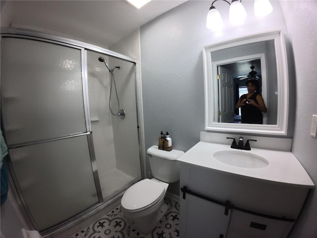 bathroom with a stall shower, vanity, and toilet