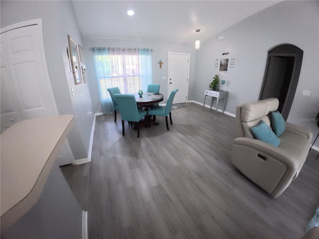 dining room with dark wood-style floors, baseboards, and vaulted ceiling