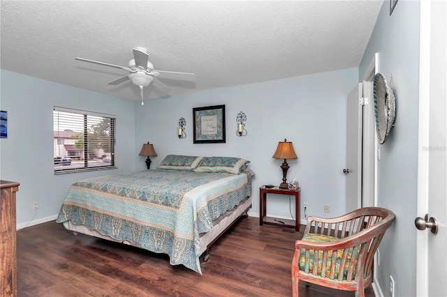 bedroom featuring ceiling fan, a textured ceiling, baseboards, and wood finished floors