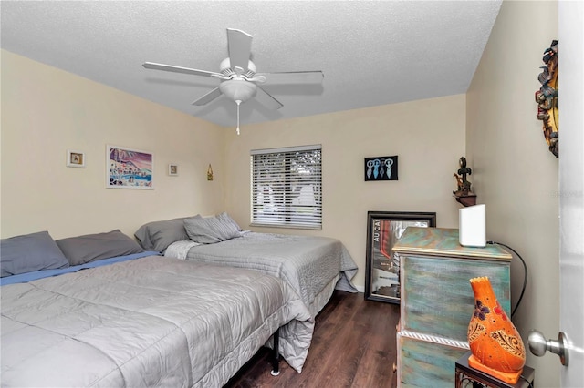 bedroom featuring dark wood-style floors, a textured ceiling, and a ceiling fan