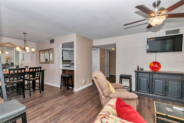 living area with dark wood-style flooring, visible vents, and a textured ceiling