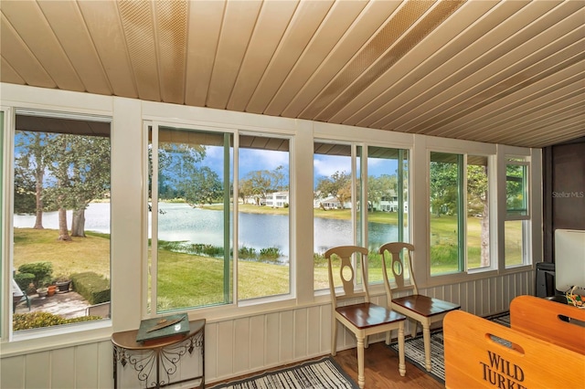 sunroom / solarium with a water view, wooden ceiling, and a healthy amount of sunlight