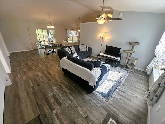 living area featuring visible vents, vaulted ceiling, baseboards, and wood finished floors