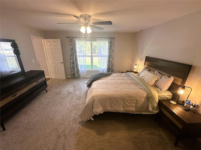 carpeted bedroom featuring a textured ceiling, ceiling fan, and baseboards