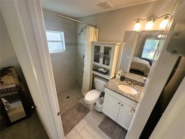 ensuite bathroom with visible vents, a tile shower, a wealth of natural light, and ensuite bathroom