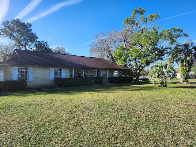 view of front of house featuring a front yard and concrete block siding