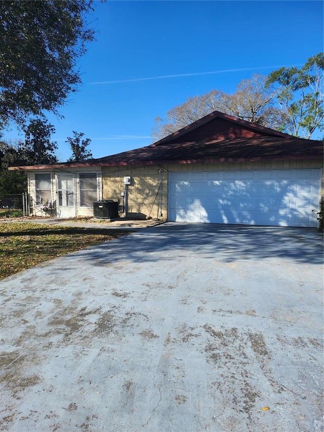 view of side of home with driveway and central AC unit