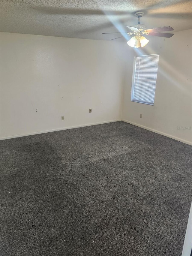 unfurnished room featuring a ceiling fan, dark colored carpet, and a textured ceiling