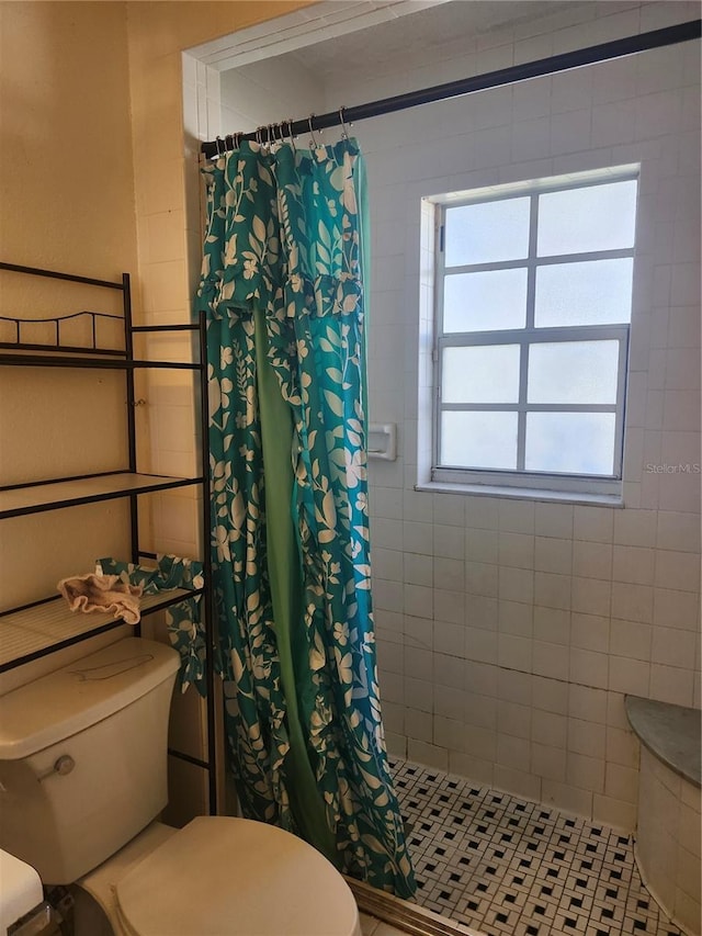 full bath with a tile shower and toilet