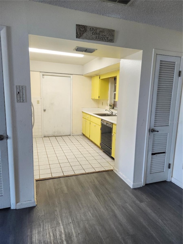 kitchen with visible vents, light countertops, light wood-style flooring, a sink, and dishwasher