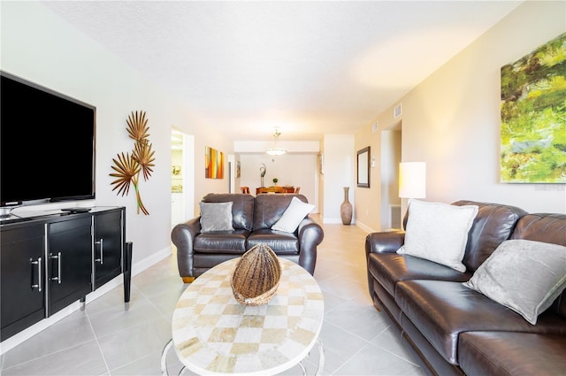 living room featuring light tile patterned floors, visible vents, and baseboards