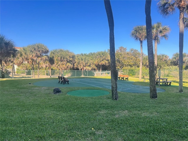 view of property's community featuring a yard and fence