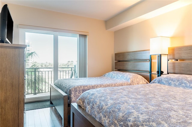 bedroom with wood finished floors and access to exterior