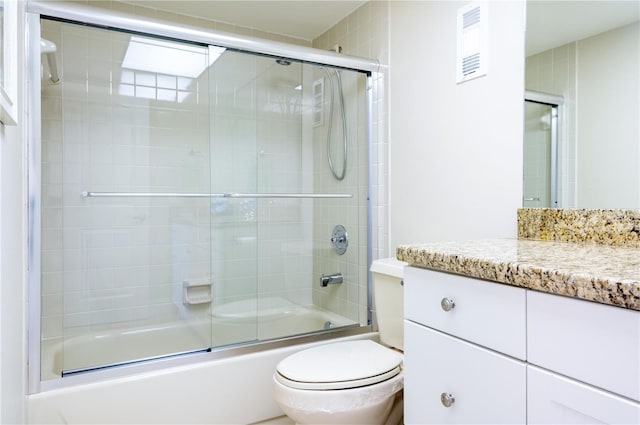 bathroom featuring toilet, shower / bath combination with glass door, and vanity