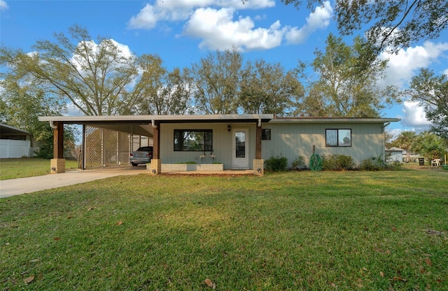 view of front of house with an attached carport, concrete driveway, and a front lawn