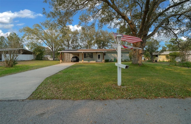 ranch-style home featuring a carport, a front yard, concrete driveway, and fence