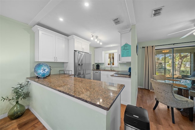 kitchen featuring appliances with stainless steel finishes, wood finished floors, and visible vents