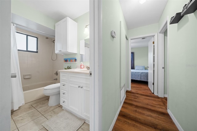 full bath featuring shower / bathtub combination with curtain, toilet, vanity, tile patterned flooring, and baseboards