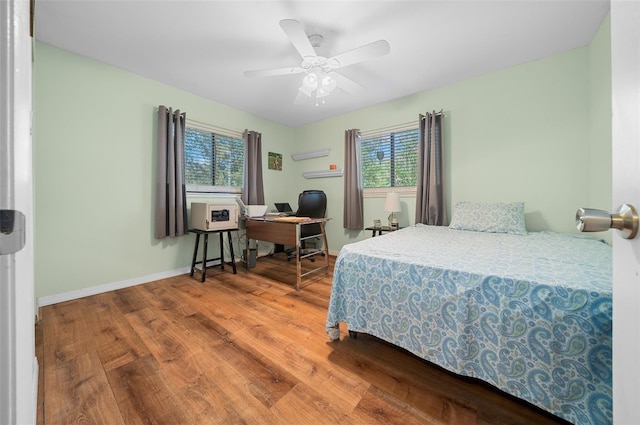 bedroom featuring ceiling fan, baseboards, and wood finished floors