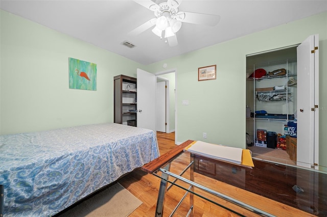 bedroom featuring a closet, visible vents, a spacious closet, a ceiling fan, and light wood-type flooring