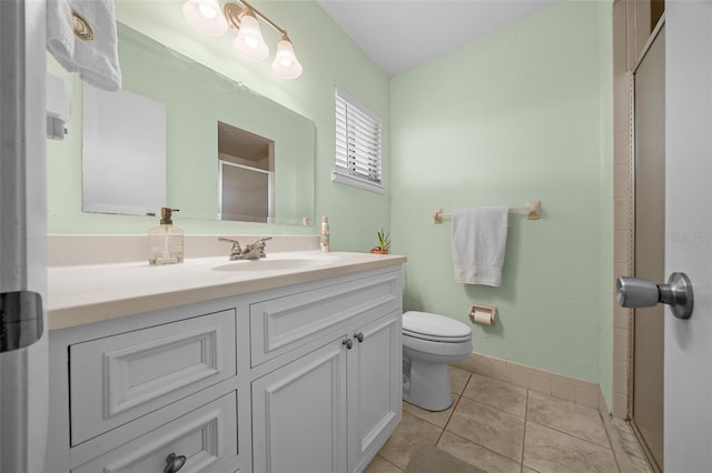 full bath featuring tile patterned flooring, toilet, vanity, baseboards, and a shower stall