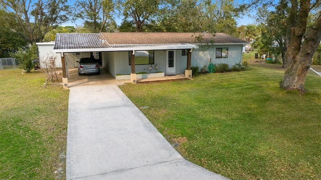 single story home featuring driveway, a carport, and a front yard