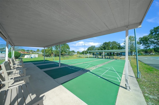 surrounding community with shuffleboard and a lawn