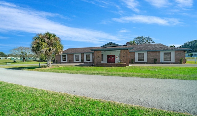 view of front of property featuring brick siding and a front lawn