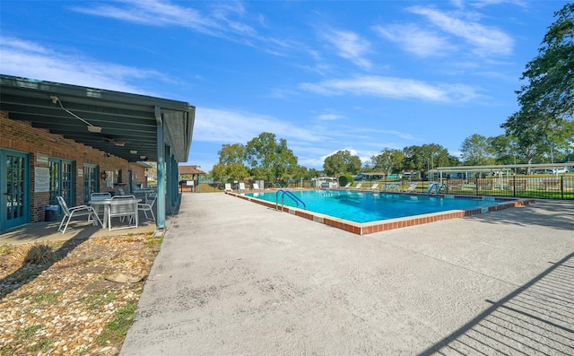 pool featuring a patio, fence, and a ceiling fan